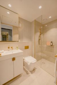 a bathroom with a toilet and a sink and a shower at Sky One Grand Terrace Penthouse in Box Hill +42 photos