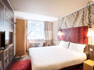 a hotel room with a large bed and a tv at Ibis Gdansk Stare Miasto in Gdańsk +111 photos