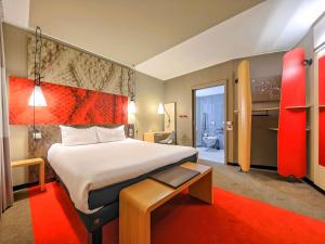 a hotel room with a large bed and a red rug at Ibis Gdansk Stare Miasto in Gdańsk