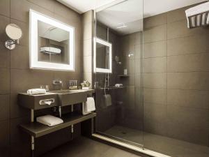 a bathroom with a sink and a shower at Novotel Jeddah Tahlia in Jeddah
