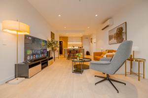 a living room with a couch and a chair at Sky One Grand Terrace Penthouse in Box Hill