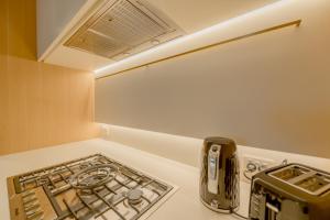 a stove top oven sitting on top of a kitchen counter at Sky One Grand Terrace Penthouse in Box Hill