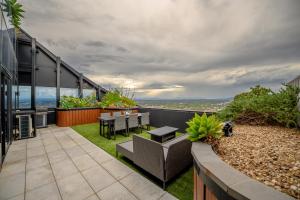 an outdoor patio with a table and chairs on a building at Sky One Grand Terrace Penthouse in Box Hill