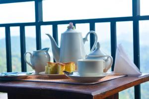 a table with cups and tea pots and toast at Wounder Mountain view ella in Medaperuwa