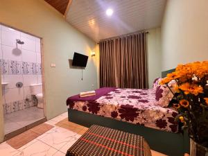 a bedroom with a bed and a bathroom at Cio Adventure Hotel in Berastagi
