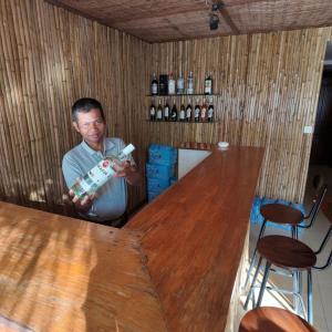 a man standing in a room with a wooden table at Champey Villa in Siem Reap