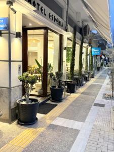 a building with a row of potted plants on a street at ESPERIA Drama HOTEL in Drama