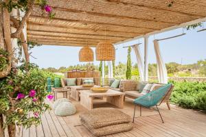 a patio with a couch and a table and chairs at Villa Charming House in La Mola