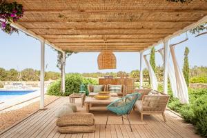 a patio with a table and chairs and a pool at Villa Charming House in La Mola