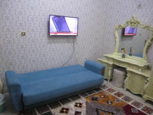 a living room with a blue couch and a tv at العين الهيلي مصباح بيت 13 in Al Ain