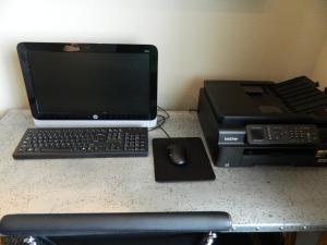 a laptop computer sitting on a desk next to a printer at Brookstone Lodge & Suites in Algona