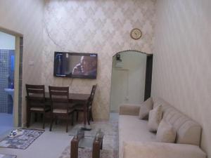 a living room with a couch and a tv on the wall at العين الهيلي مصباح بيت 13 in Al Ain