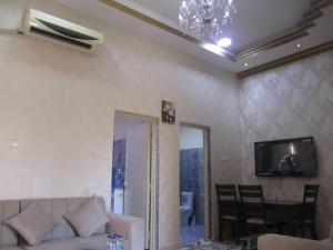 a living room with a couch and a tv at العين الهيلي مصباح بيت 13 in Al Ain