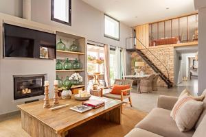a living room with a table and a fireplace at Villa Charming House in La Mola
