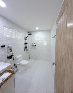 a white bathroom with a toilet and a sink at Labelle villa koh phangan in Ko Phangan +56 photos