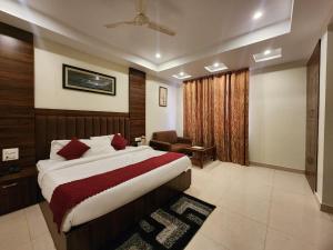 a bedroom with a bed and a chair in a room at Kanta International near katra railway station in Katra +16 photos