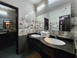 a bathroom with two sinks and a large mirror at Kanta International near katra railway station in Katra