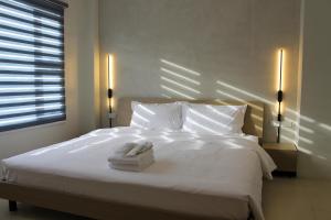 a bedroom with a white bed with two towels on it at The Perch Hostel in Olongapo