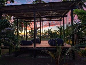 a gazebo with pillows on it with a sunset at Fanifo Lofa in Ha’apai