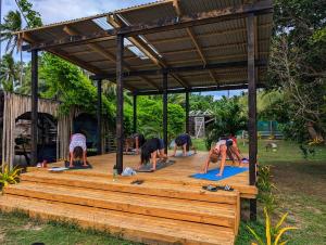 a group of people doing yoga on a wooden deck at Fanifo Lofa in Ha’apai +32 photos