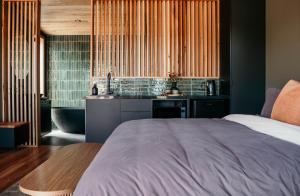 a bedroom with a bed and a bathroom with a sink at 3 Acres by the Moyne in Port Fairy