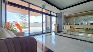a living room with a large glass wall at Remas Hotel Hat Yai in Ban Tha Thon