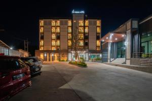 a building with a car parked in front of it at Remas Hotel Hat Yai in Ban Tha Thon
