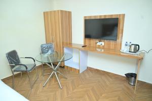 a room with a glass table and a tv on a wall at Hotel aditya palace in Padrauna