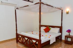 a bed with a canopy in a room at Abhimani Bungalows in Aluthgama