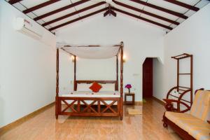 a room with a bed with a canopy and a couch at Abhimani Bungalows in Aluthgama