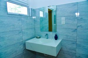a bathroom with a white sink and a mirror at Abhimani Bungalows in Aluthgama
