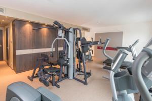a gym with several tread machines in a room at Looken Inn in Lingen