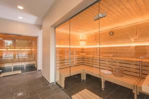 a sauna with wood paneling and a glass wall at Looken Inn in Lingen