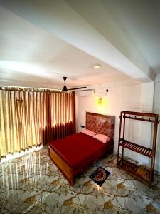 a bedroom with a red bed in a room at Sandaruwan villa in Ratgama Hegoda