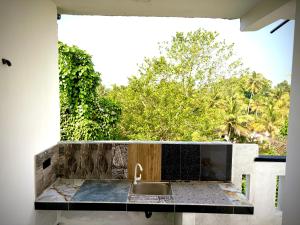 a kitchen counter with a sink and a window at Sandaruwan villa in Ratgama Hegoda