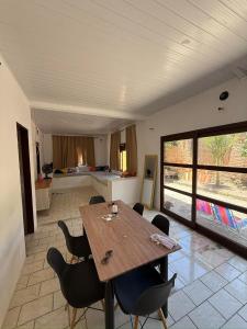 a dining room with a wooden table and chairs at Temporada Verão in Prado +14 photos