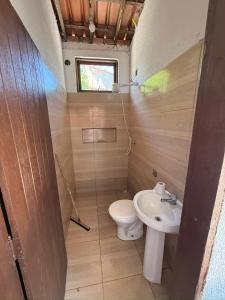 a small bathroom with a toilet and a sink at Temporada Verão in Prado