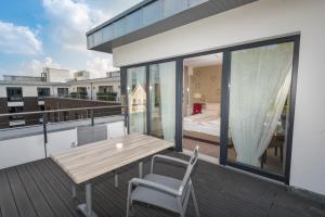 a balcony with a wooden table and chairs and a bed at Looken Inn in Lingen