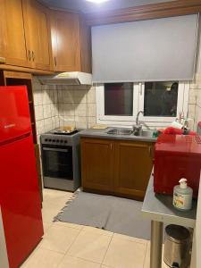 a kitchen with a red refrigerator and a stove at Χαίρε, ξεΐνε, παρ' αμμι φιλησεαι in Tríkala
