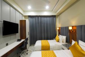 a hotel room with two beds and a flat screen tv at HOTEL BREEZE BAY EX - NEAR US Consulate, BKC in Mumbai +24 photos