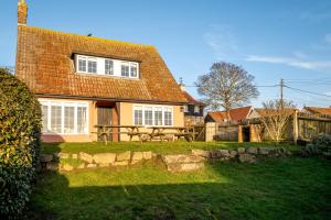 a house with a picnic table in front of it at Sanctuary House in Thorpeness
