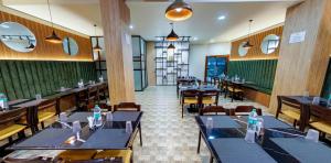 a restaurant with tables and chairs in a room at THE CONTINENTAL INN & SUITES in Mysore