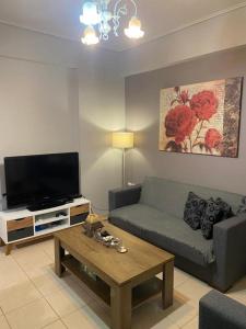 a living room with a couch and a tv at Χαίρε, ξεΐνε, παρ' αμμι φιλησεαι in Tríkala