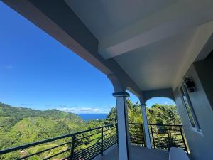 a room with a balcony with a view of the ocean at Vacation Guesthouse in Paix Bouche