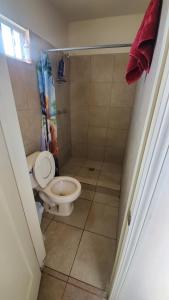 a small bathroom with a toilet and a shower at Depa Jardines Anahuac in Mexicali