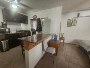 a kitchen with a counter and a table and a bed at Depa Jardines Anahuac in Mexicali