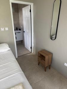 a bedroom with a bed and a mirror on the wall at Vacation Guesthouse in Paix Bouche