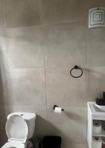 a bathroom with a toilet and a roll of toilet paper at Vacation Guesthouse in Paix Bouche +5 photos