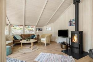 a living room with a couch and a fireplace at 1445 Aakirkeby - Poserekrogen 13 in Vester Sømarken