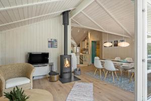 a living room with a fireplace and a dining room at 1445 Aakirkeby - Poserekrogen 13 in Vester Sømarken